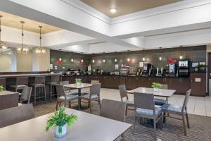 a restaurant with tables and chairs and a bar at Best Western Plus Overland Inn in Fort Morgan
