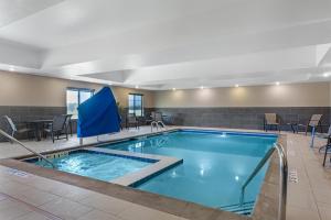 a pool with chairs and tables in a hotel room at Best Western Plus Overland Inn in Fort Morgan