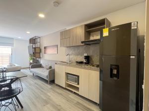 a kitchen with a refrigerator and a living room at Parque de La 93 - Elite Flats in Bogotá