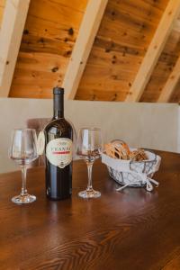 a bottle of wine and two glasses on a table at Sunrise House in Plužine