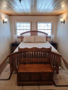 a bedroom with a wooden bed and two windows at Back Bay Getaway in Hayward