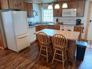 a kitchen with a white refrigerator and a table with chairs at Back Bay Getaway in Hayward