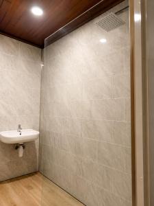 a bathroom with a sink and a tiled wall at The Promenade House in New Brighton +18 photos