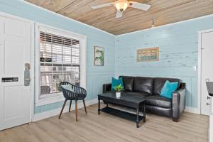 a living room with a leather couch and a table at Parrot Beach Cottages Suite #4 in Siesta Key