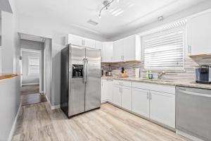 a kitchen with white cabinets and a stainless steel refrigerator at Don't Be Koi in Bradenton