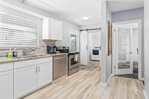 a kitchen with white cabinets and stainless steel appliances at Don't Be Koi in Bradenton