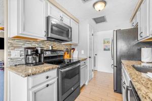 a kitchen with a stove and a refrigerator at Holmes Beach Bungalow - B in Holmes Beach