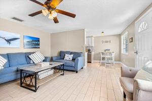 a living room with a blue couch and a ceiling fan at Holmes Beach Bungalow - B in Holmes Beach