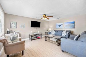 a living room with a couch and a flat screen tv at Holmes Beach Bungalow - B in Holmes Beach