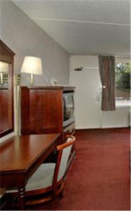 a kitchen with a wooden table and a table and a room at Travel Inn in Birmingham