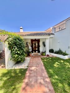 a white house with a pathway leading to the front door at Olmo tree in Vista Hermosa