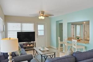 a living room with a couch and a flat screen tv at Bungalow A in Bradenton Beach