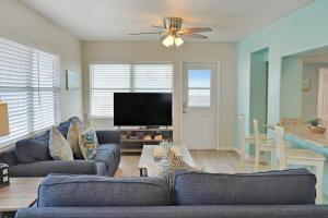 a living room with two couches and a flat screen tv at Bungalow A in Bradenton Beach
