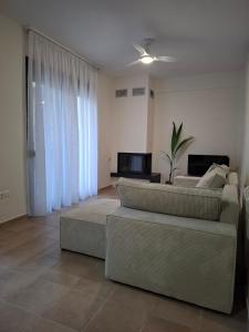 a living room with a couch and a table at aganta apartments in Olympiada