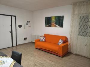 an orange couch in a room with a painting on the wall at Lary&Giù in Cadelbosco di Sopra