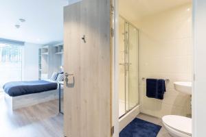 a bathroom with a shower and a toilet and a bed at ABeleven in Aberdeen +2 photos