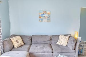 a living room with a gray couch with pillows at Bungalow W in Bradenton Beach