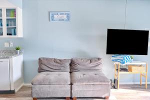 a gray couch in a living room with a tv at Bungalow W in Bradenton Beach