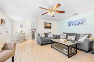 a living room with a couch and a ceiling fan at Holmes Beach Bungalow - A in Holmes Beach