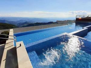 a swimming pool with blue water on top of a house at Milmari N2 Erdeg in Kopaonik