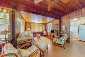 a living room filled with furniture and a kitchen at The Wee Cottage in Anna Maria