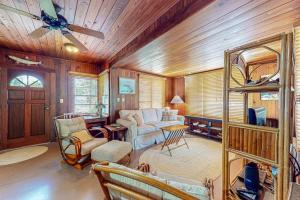 a living room with wooden walls and a ceiling at The Wee Cottage in Anna Maria