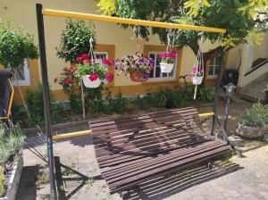 a wooden bench in front of a building with potted plants at Levendula udvarház in Sopron