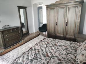 a bedroom with a bed with a dresser and a dresser at Levendula udvarház in Sopron +4 photos