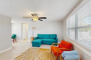 a living room with a blue couch and a ceiling fan at Pineapple House in Holmes Beach