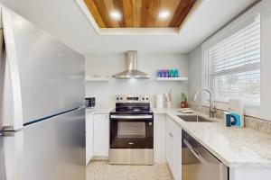 a white kitchen with a stove and a refrigerator at Pineapple House in Holmes Beach +16 photos