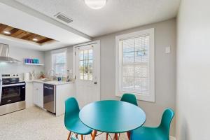 a kitchen with a blue table and chairs at Pineapple House in Holmes Beach