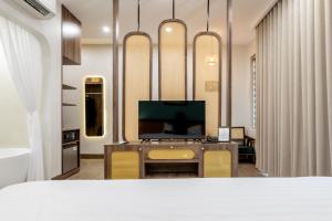a room with a tv and a desk with chairs at La May Boutique hotel in Ninh Binh
