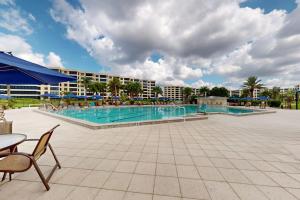 a swimming pool with chairs and a table and a building at The Aquarium in Sarasota