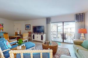 a living room with a couch and a table and a tv at Gulf Place 20 in Holmes Beach