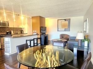 a living room with a glass table and a kitchen at Discovery Bay 3517 in Honolulu