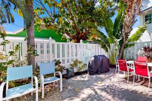 a patio with chairs and a table and a fence at Nautical Nook at Bayview Inn in Bradenton Beach
