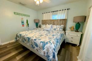 a bedroom with a bed with a blue and white comforter at Nautical Nook at Bayview Inn in Bradenton Beach