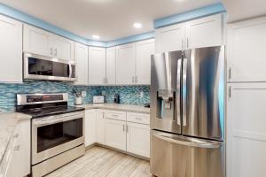 a kitchen with white cabinets and a stainless steel refrigerator at Gulf Place 19 & 20 in Holmes Beach