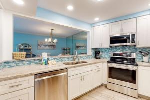 a large kitchen with white cabinets and blue walls at Gulf Place 19 & 20 in Holmes Beach