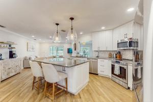 a kitchen with white cabinets and a table and chairs at Poseidons Palace in Sarasota +32 photos