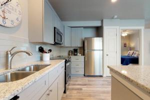 a kitchen with white cabinets and a stainless steel refrigerator at South Bay Inn 3 in Anna Maria