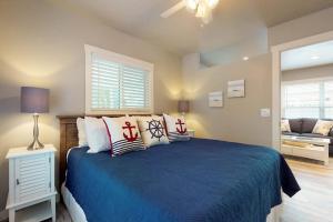 a bedroom with a blue bed and a living room at South Bay Inn 3 in Anna Maria
