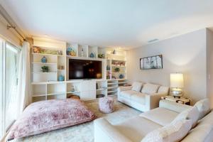 a living room with a couch and a tv at 10 Pines - Sarasota Bay in Sarasota