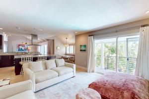 a living room with a white couch and a kitchen at 10 Pines - Sarasota Bay in Sarasota