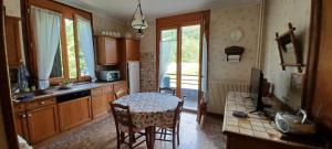 a kitchen with a table and chairs in a room at Appartement Marthod in Marthod