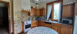 a kitchen with wooden cabinets and a table in it at Appartement Marthod in Marthod