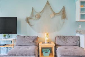 a living room with two chairs and a table with a lamp at Bungalow E in Bradenton Beach