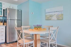 a kitchen with a table with chairs and a refrigerator at Bungalow E in Bradenton Beach