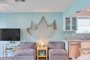 a living room with two chairs and a kitchen at Bungalow E in Bradenton Beach +20 photos