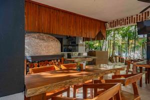 a restaurant with a large wooden table and wooden chairs at Niik Tulum in Tulum